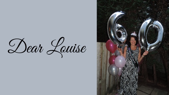 Smiling woman holding birthday balloons