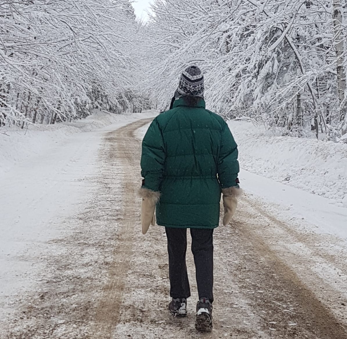 woman walking on a snow covered country road