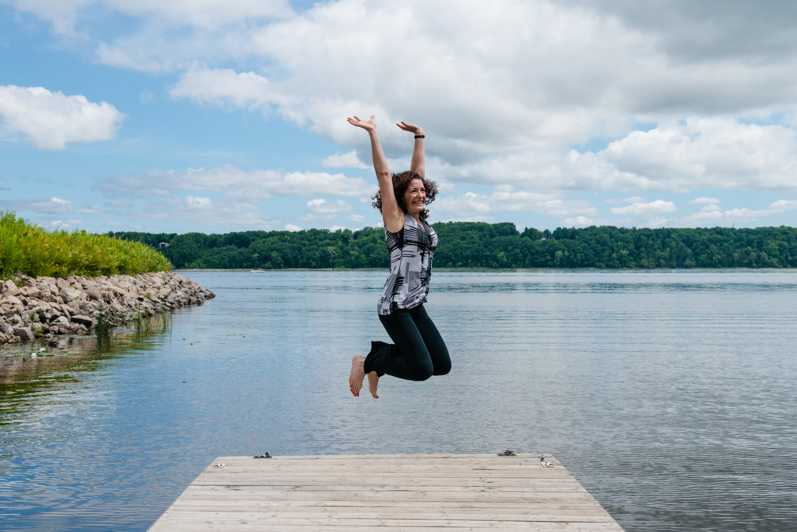 Woman standing on a dock and jumping